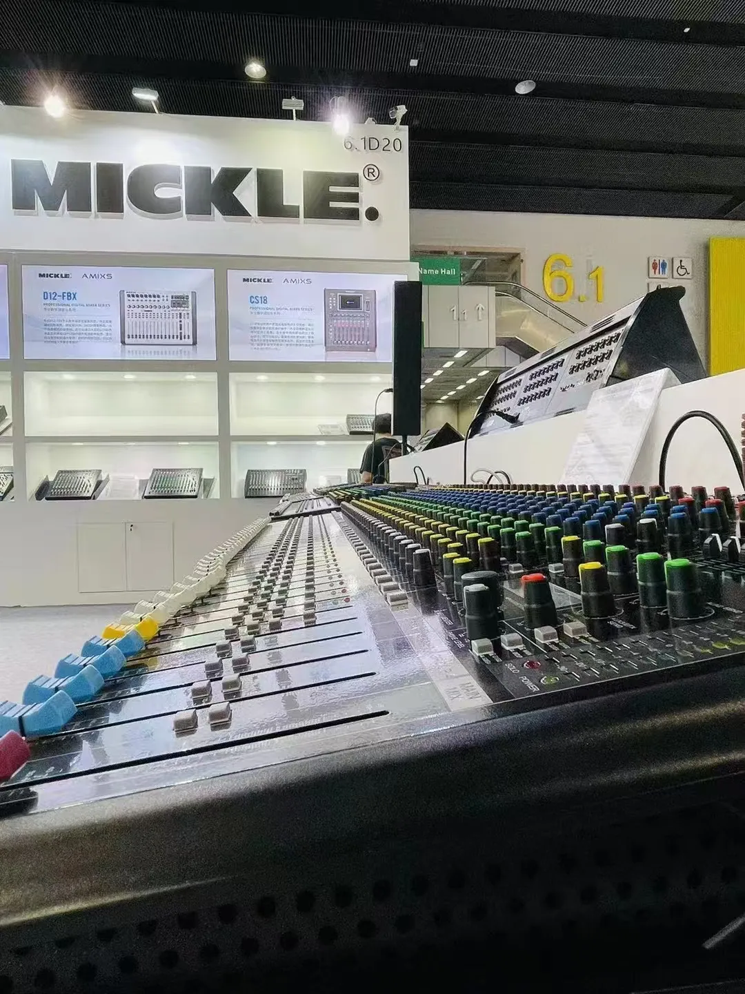 Analog mixing console displayed in front of the MICKLE AUDIO booth